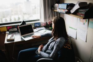 Student sits in front of laptop