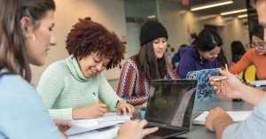 A group of students study together around a table.