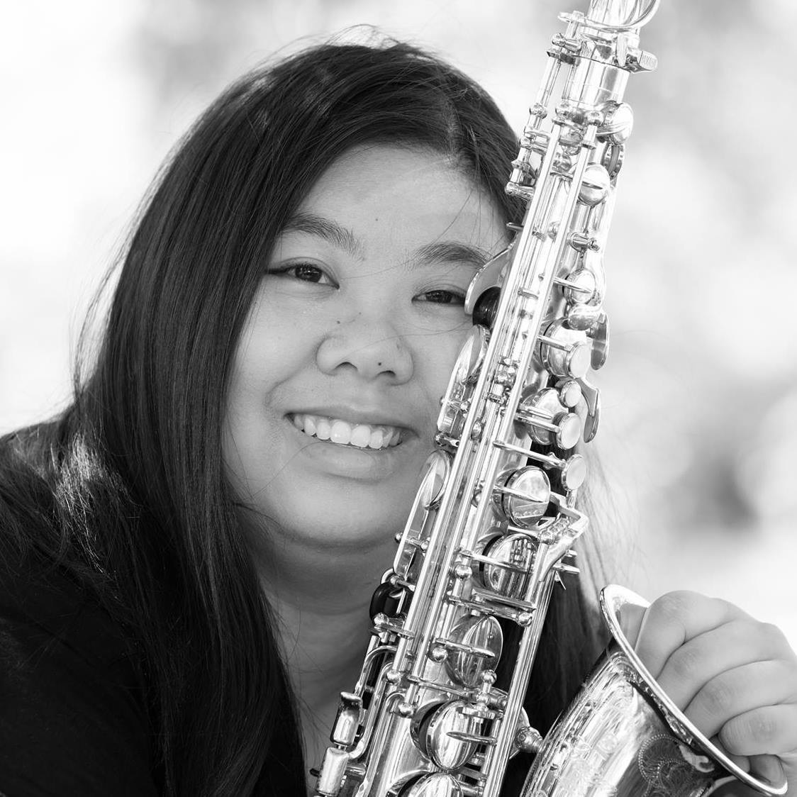 A portrait of Tina Wang with her saxophone