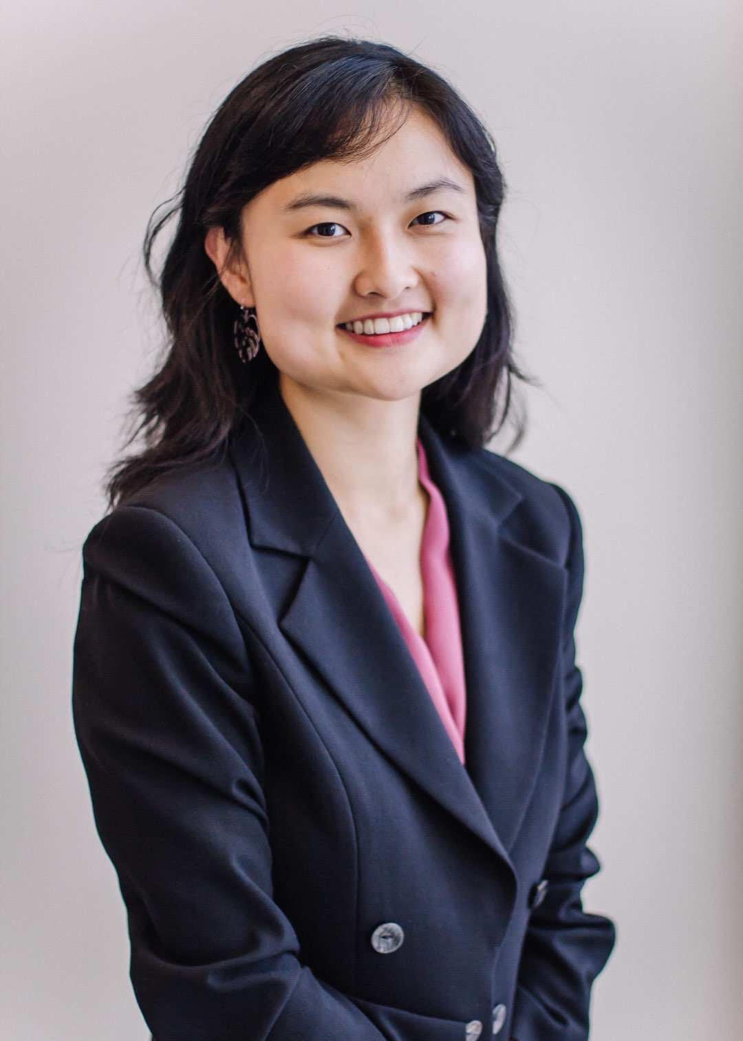 A professional headshot of Nemo Anyudan Zhao. She is wearing a dark blue blazer over a pink blouse.