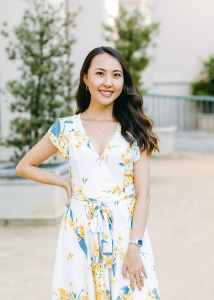 Full-body portrait imager of Isabel Peng, a young Asian woman wearing a white dress with a floral print.