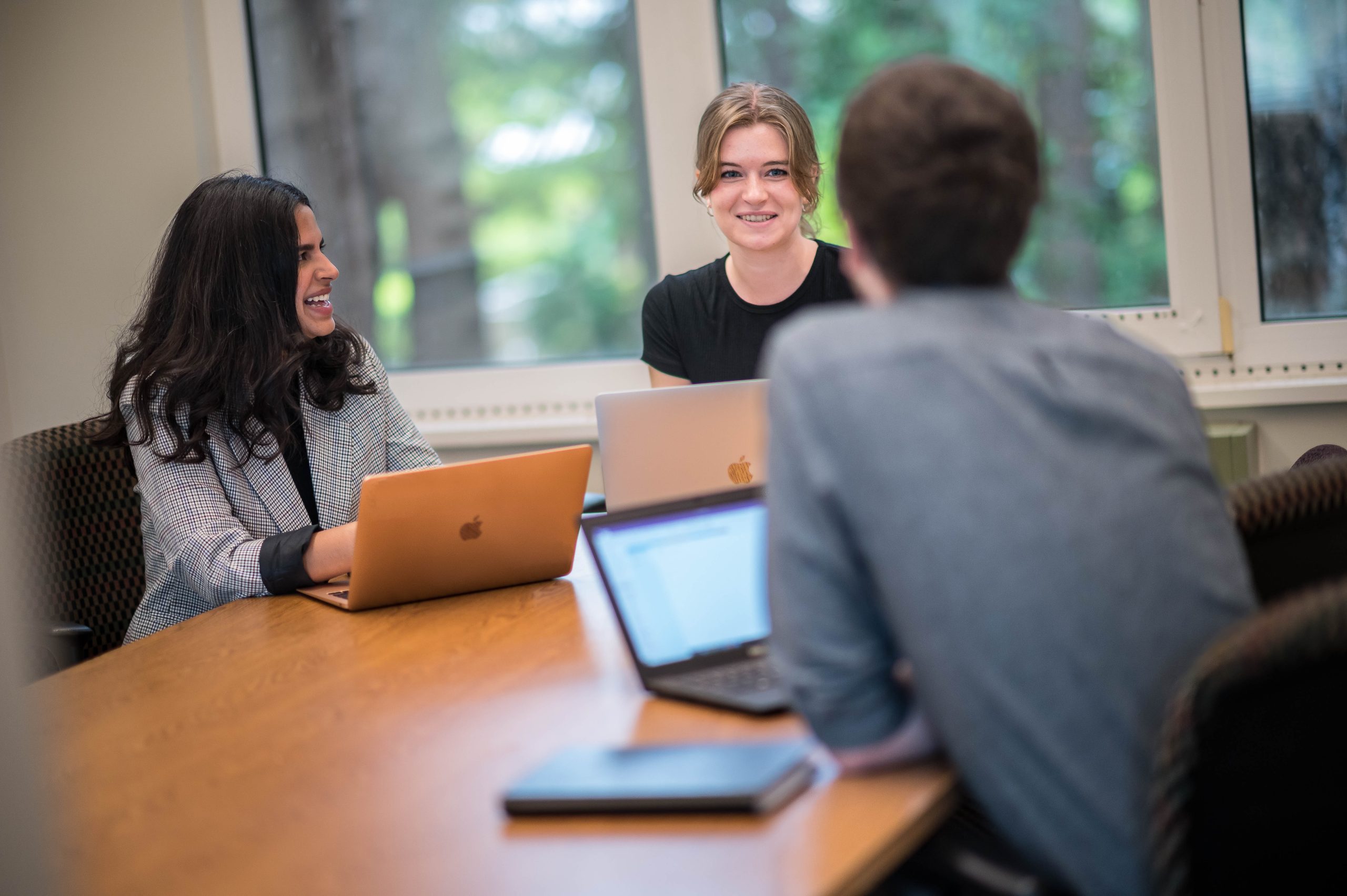 Three students having a discussion at a study room table.